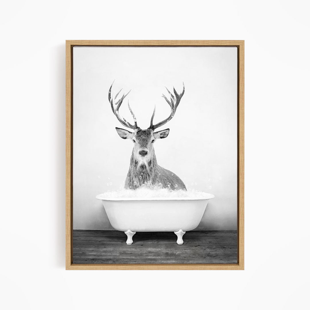 A deer with large antlers is sitting in a bathtub filled with water, creating a whimsical and unexpected scene.