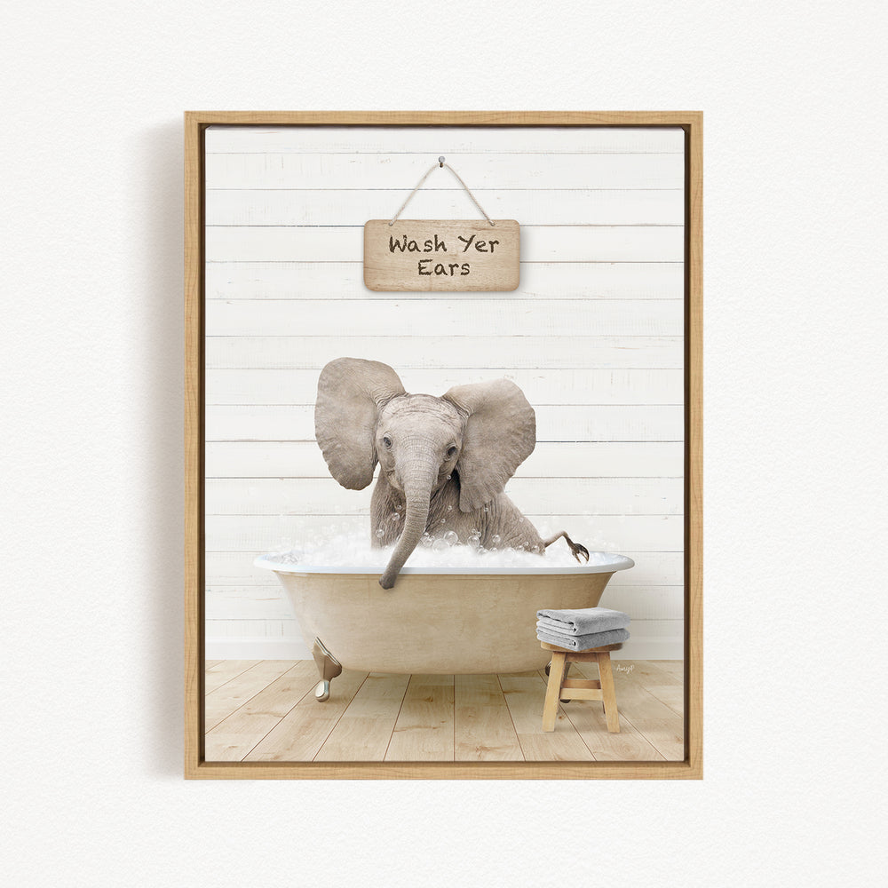 A gray elephant is sitting in a bathtub filled with water, with a sign above it that says "Wash Yer Ears".