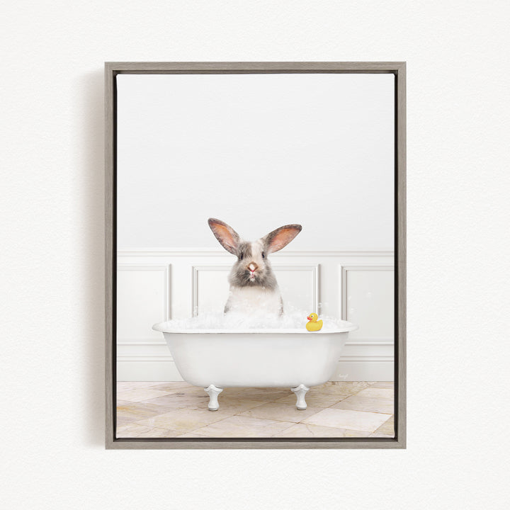 A white rabbit sitting in a white bathtub filled with bubbles, with a rubber duck floating in the water.