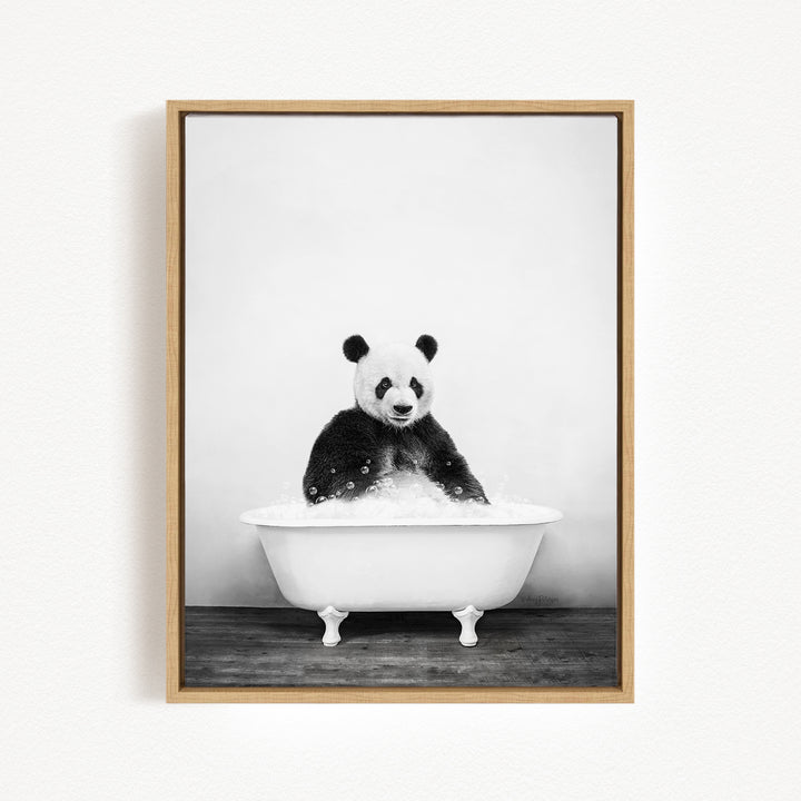 A panda bear sitting in a white bathtub filled with bubbles, looking directly at the camera.