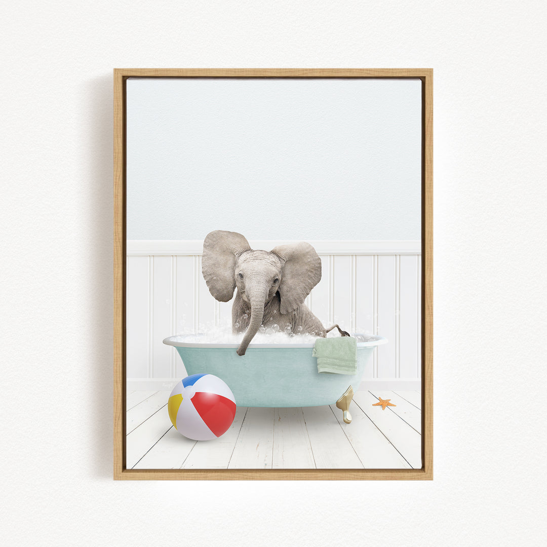 A baby elephant sitting in a bathtub filled with water, surrounded by a beach ball and a towel.