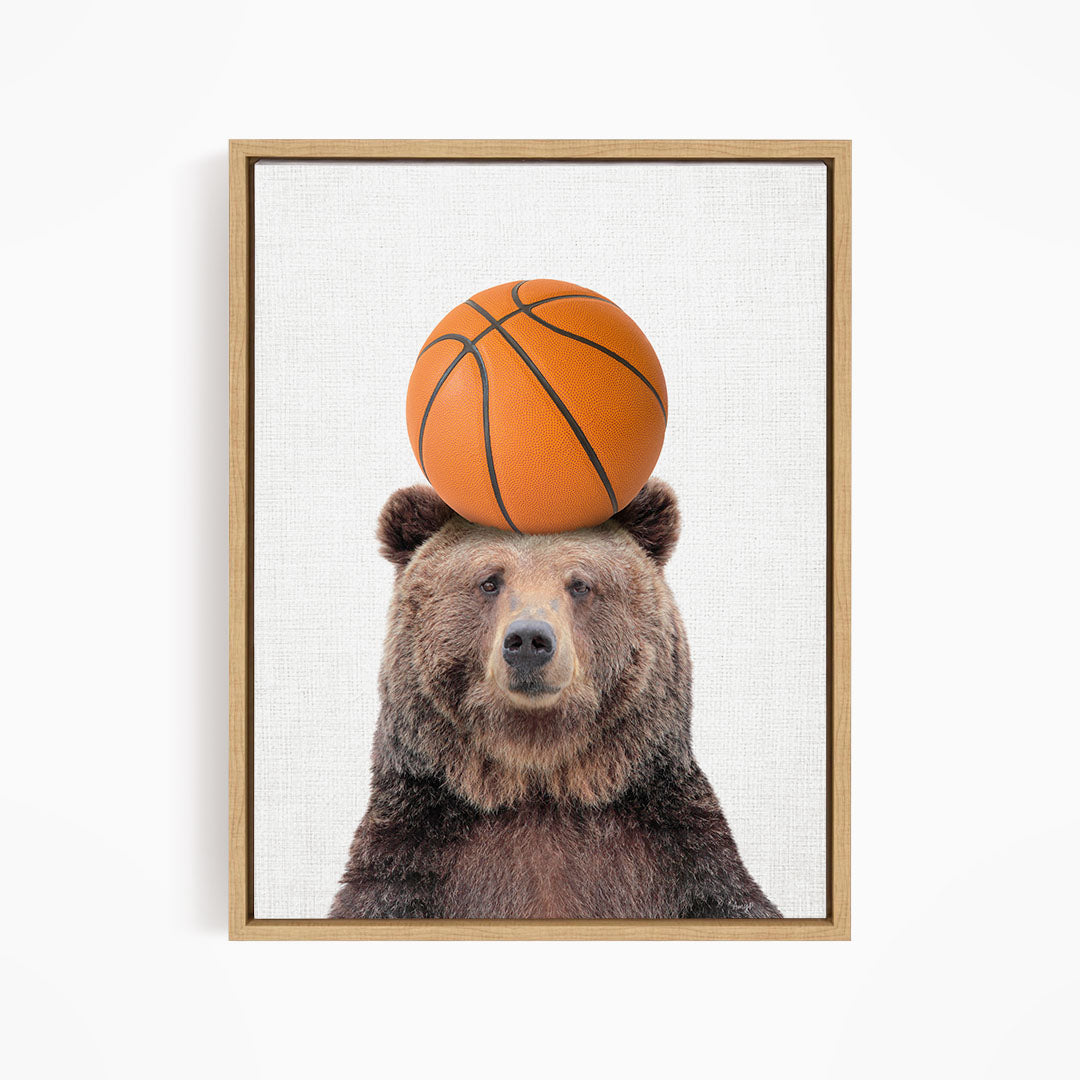 A brown bear balancing a basketball on its head.