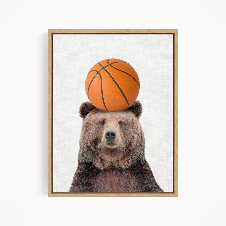 A brown bear balancing a basketball on its head.