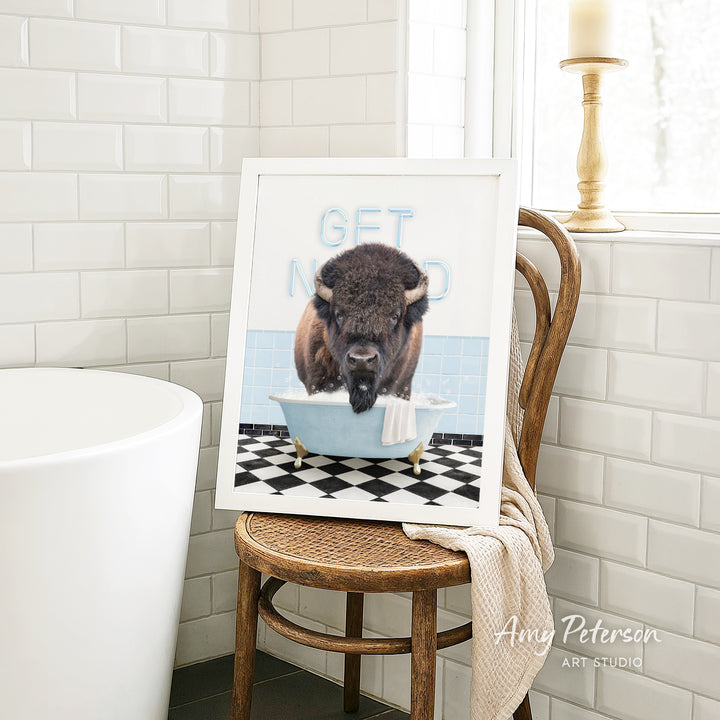 A framed image of a buffalo sitting in a bathtub, with the text "GET NICKED" written on the frame.