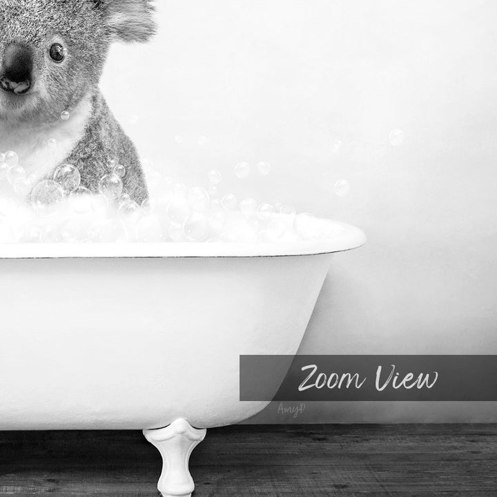 A koala sitting in a bathtub filled with bubbles, as captured in a black and white image.