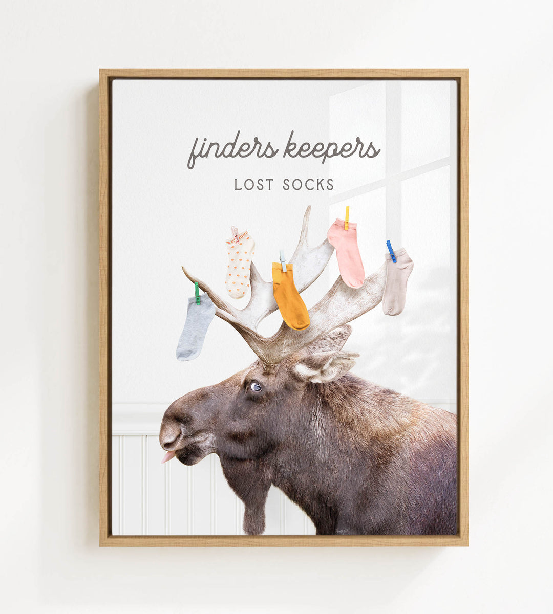 A moose with a pile of colorful socks on its head, accompanied by the text "finders keepers lost socks"