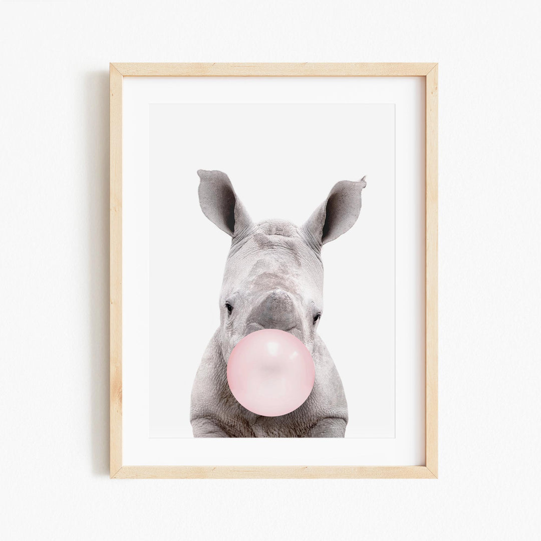 a picture of a baby giraffe chewing on a pink bubble