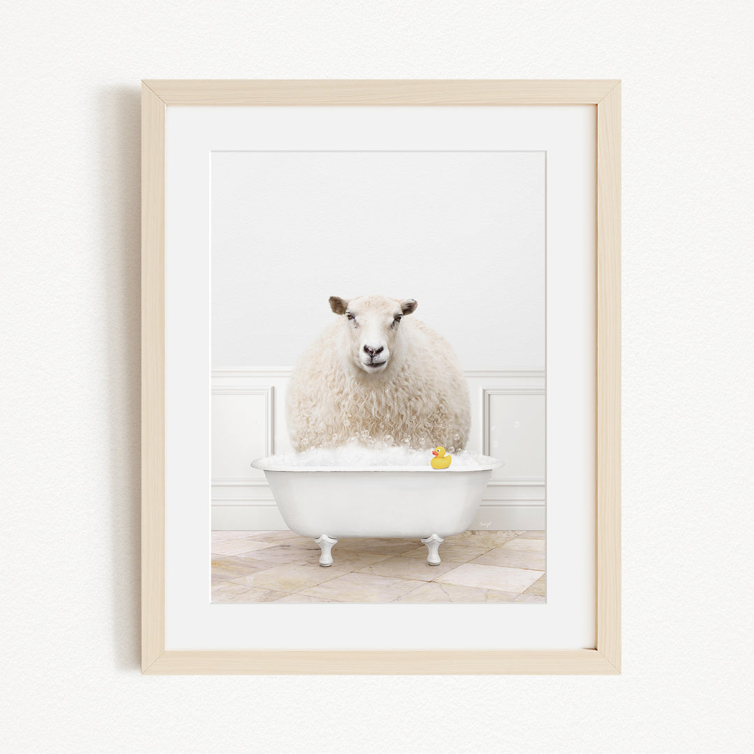 A fluffy white sheep sits in a white bathtub, with a yellow rubber duck floating in the water.