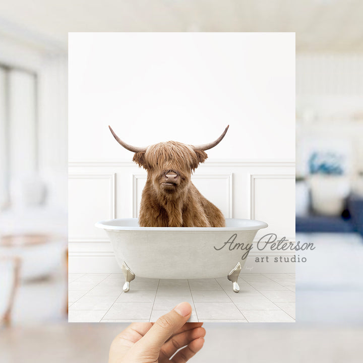 a hand holding up a card with a picture of a cow in a bathtub