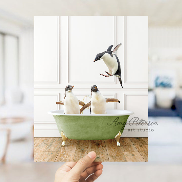 a hand holding a card with three penguins in a bathtub