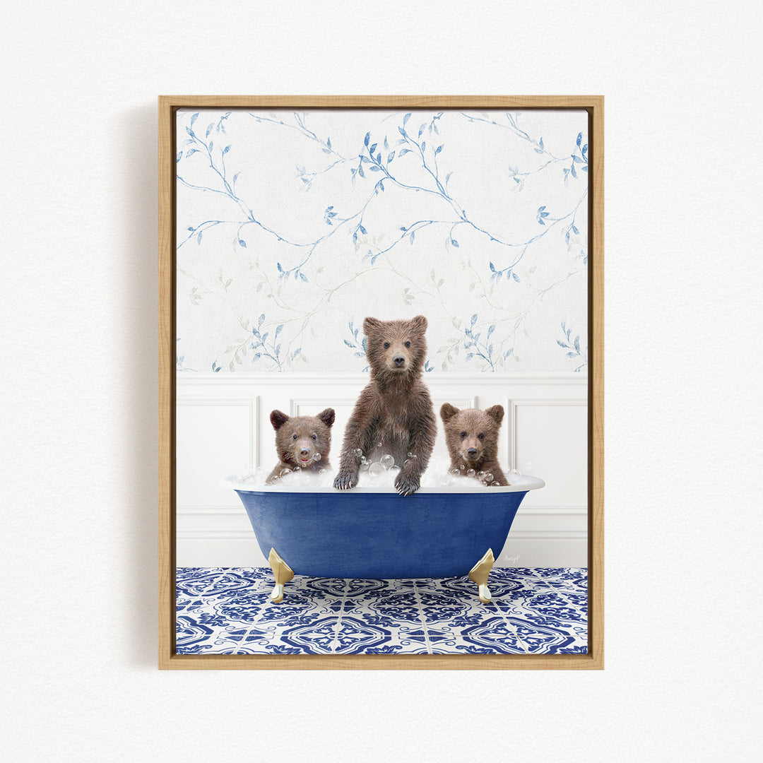 A framed image depicting three brown bears sitting in a blue bathtub, with a floral patterned wall behind them.