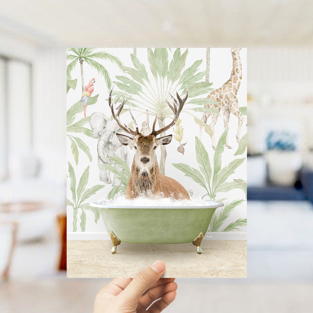 A hand holds up a print featuring a deer in a bathtub surrounded by tropical foliage, including a giraffe and palm trees.