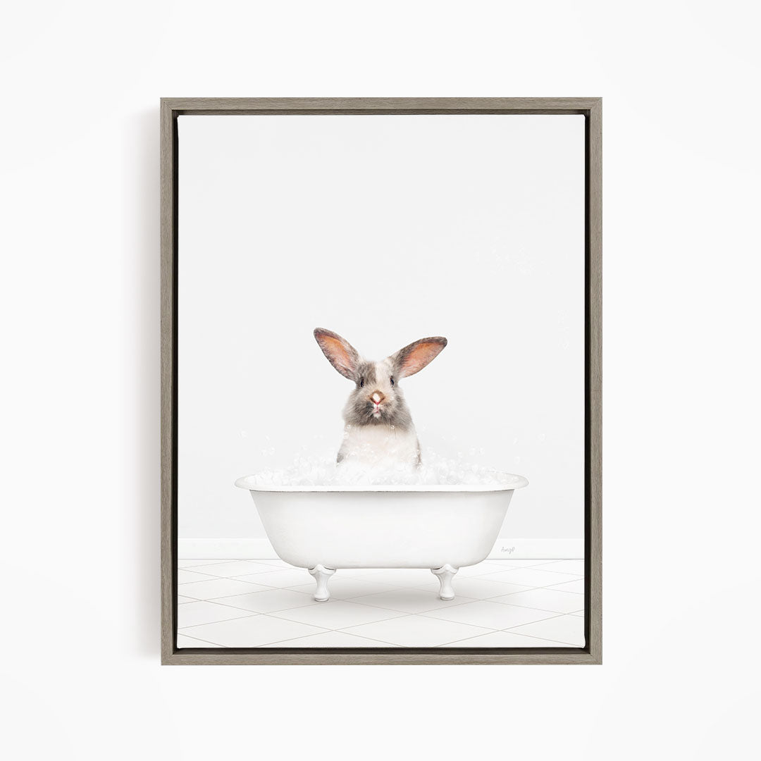 A white rabbit sitting in a white bathtub filled with water, looking up at the camera.