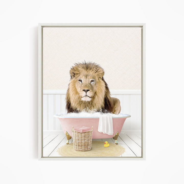 A lion sitting in a pink bathtub filled with bubbles, surrounded by a yellow rubber duck and a white towel.