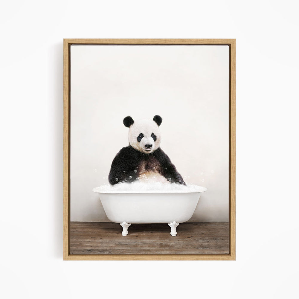 A panda bear sitting in a white bathtub filled with bubbles, looking directly at the camera.