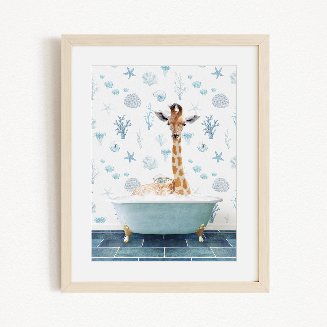 A giraffe is sitting in a bathtub filled with bubbles, surrounded by a blue and white ocean-themed wallpaper.