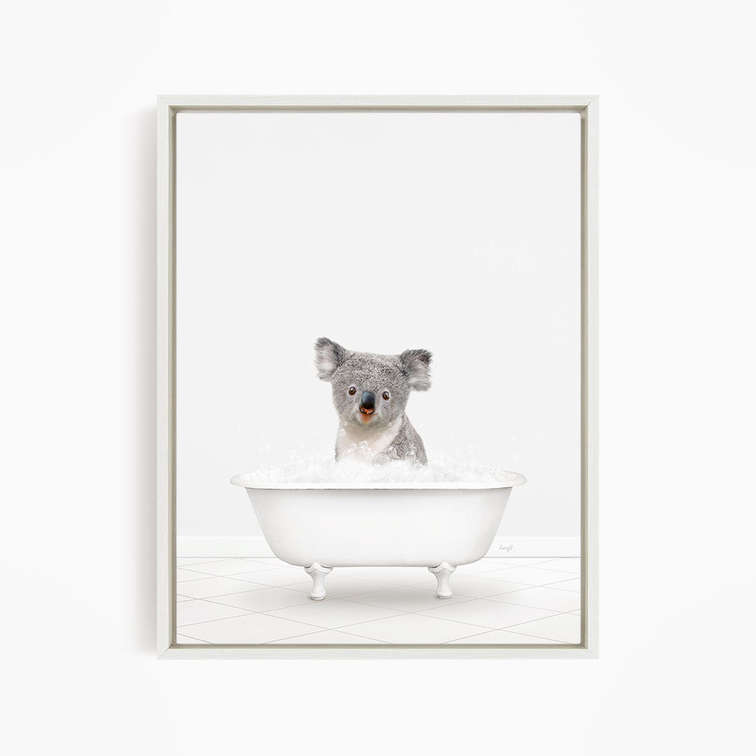 A koala sitting in a white bathtub filled with water.