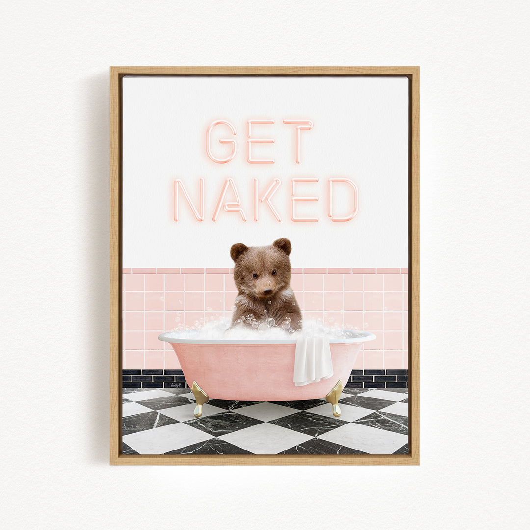 A framed image depicting a brown bear sitting in a pink bathtub filled with bubbles, with the text "GET NAKED" displayed above it.