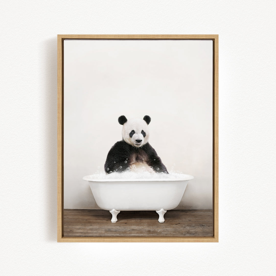 A panda bear sitting in a white bathtub filled with bubbles, looking directly at the camera.
