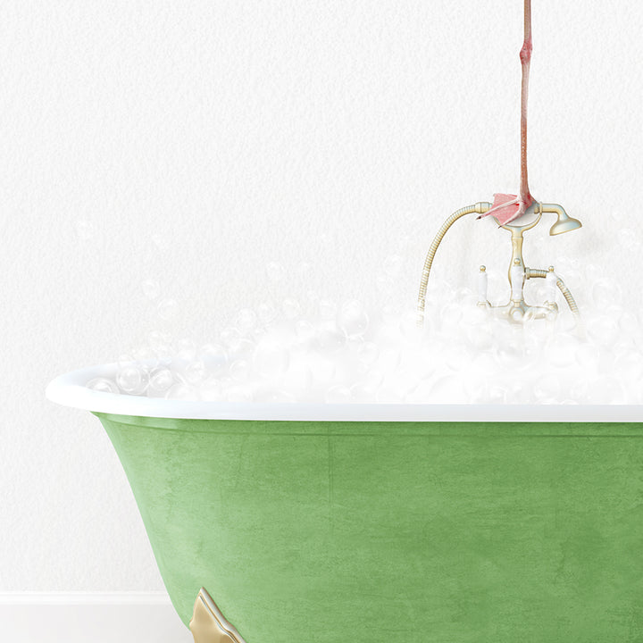 a green bathtub filled with white foam and a pink flower