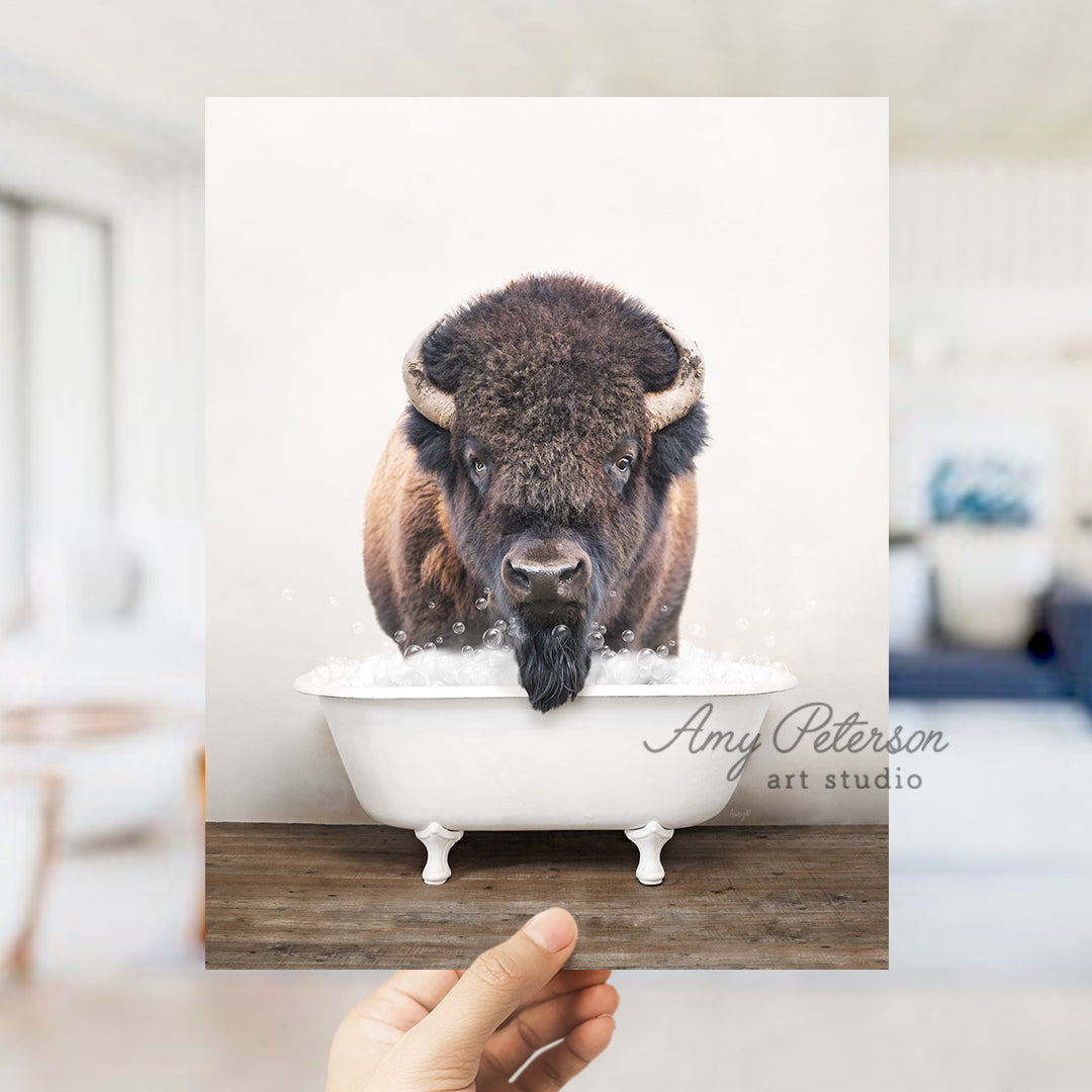 a hand holding up a card with a picture of a bison in a bathtub