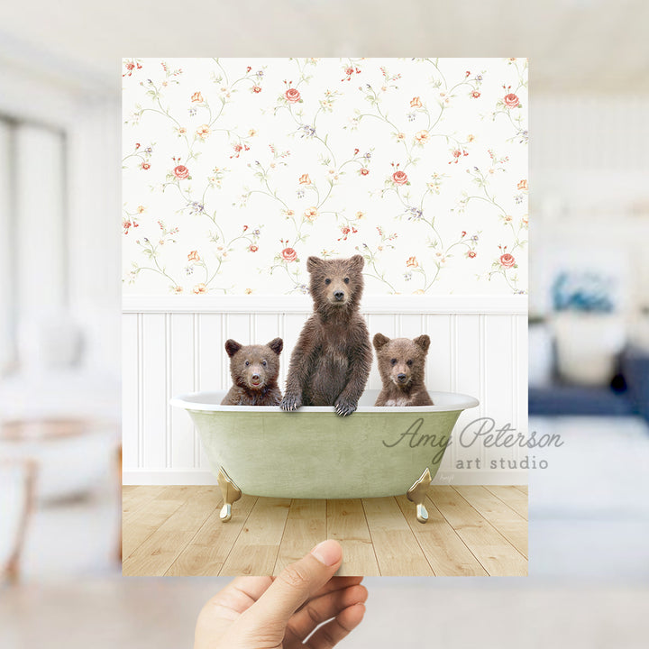 a person holding up a card with three bears in a bathtub