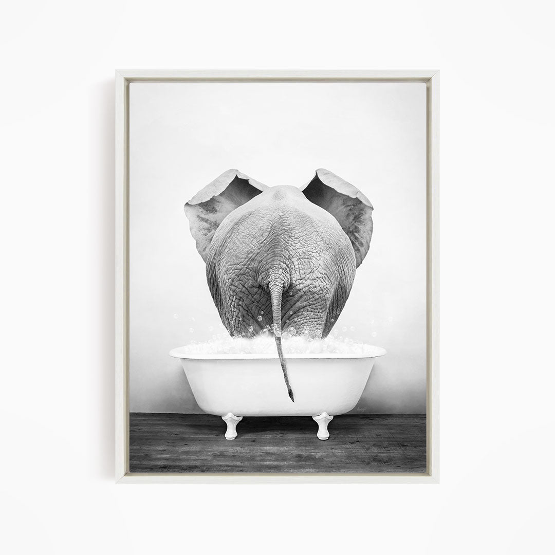 A black and white photograph of an elephant standing in a bathtub filled with water, with its trunk submerged in the water.