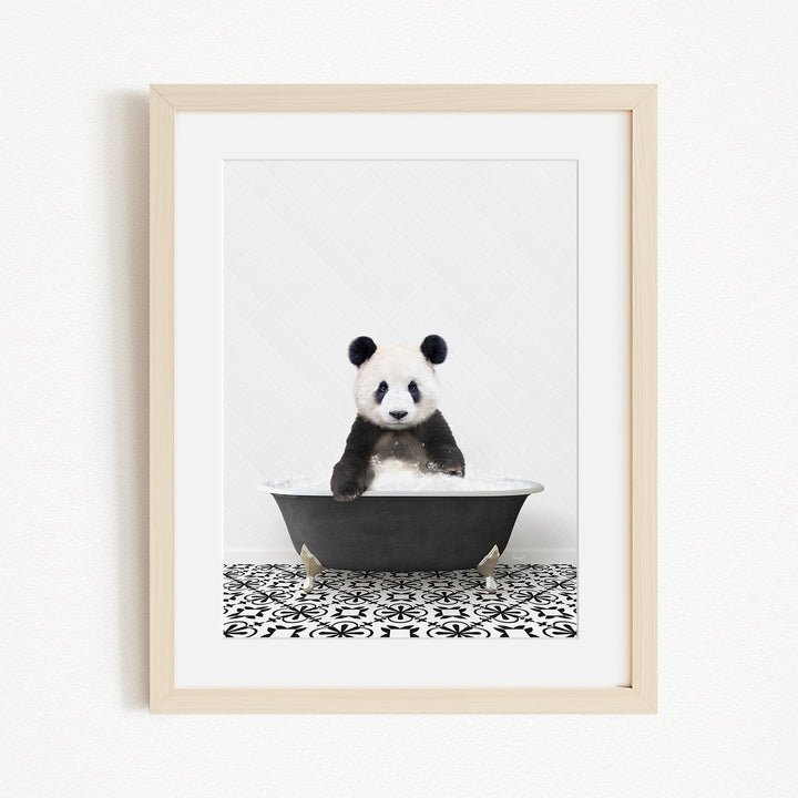 A panda bear sitting in a bathtub, surrounded by a black and white patterned floor.