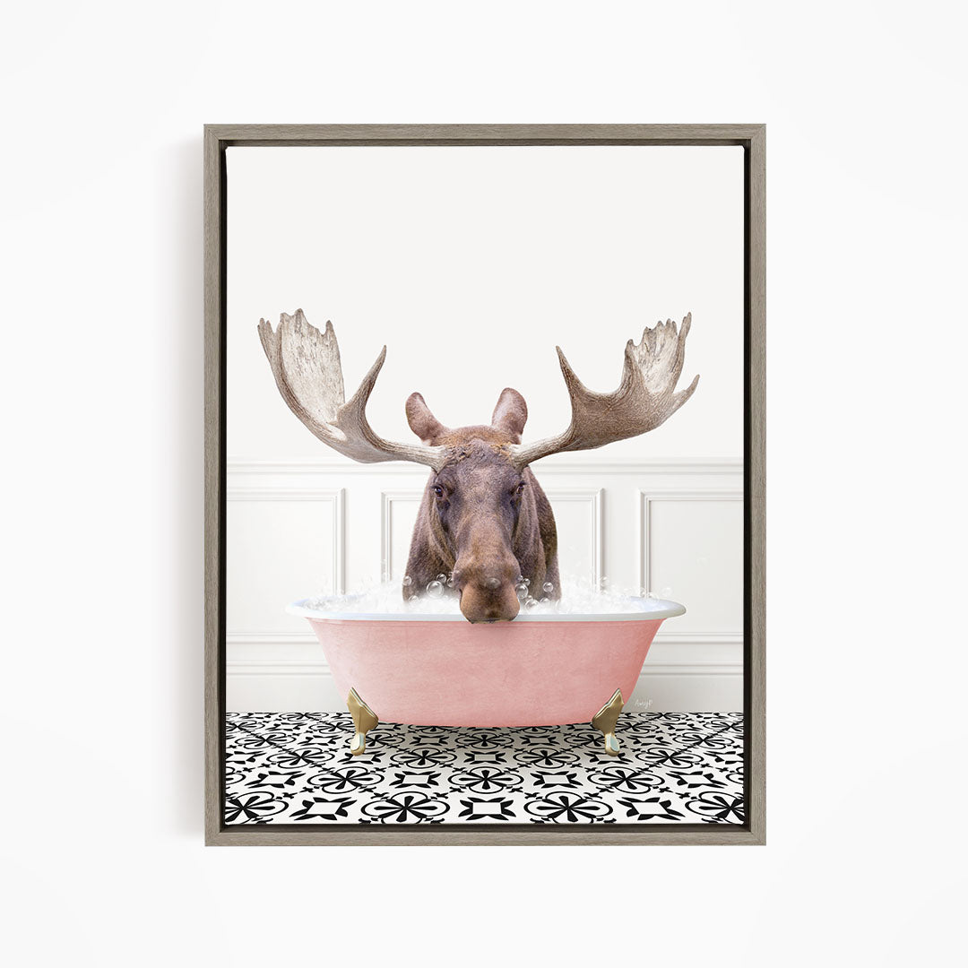 A moose with large antlers is sitting in a pink bathtub filled with water, creating a whimsical and humorous scene.