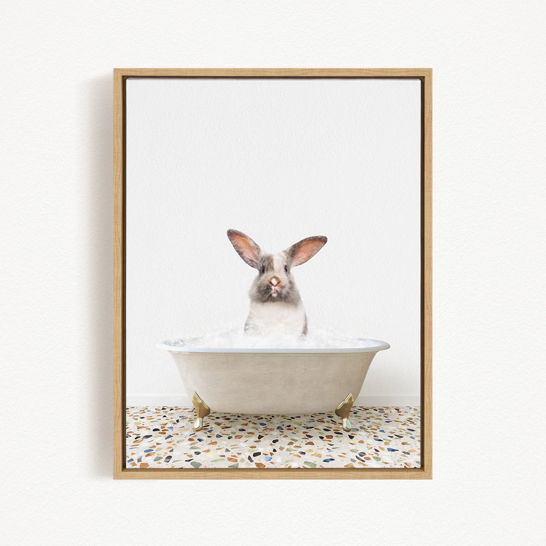 A white rabbit sitting in a white bathtub filled with water, looking directly at the camera.