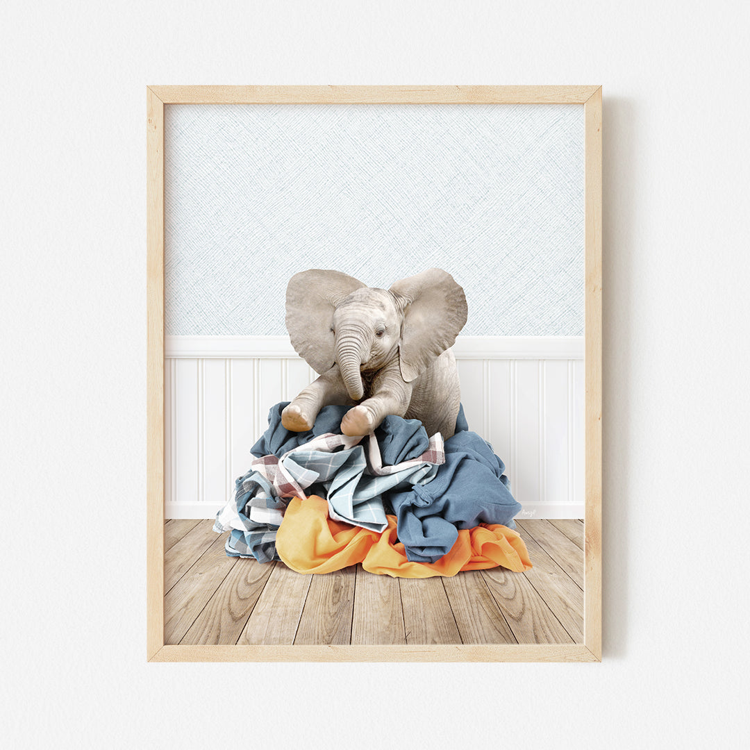 an elephant sitting on top of a pile of clothes