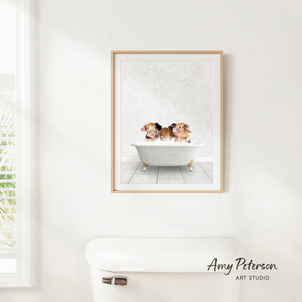 A framed print of three adorable puppies sitting in a bathtub is hanging on a white wall in a bathroom.