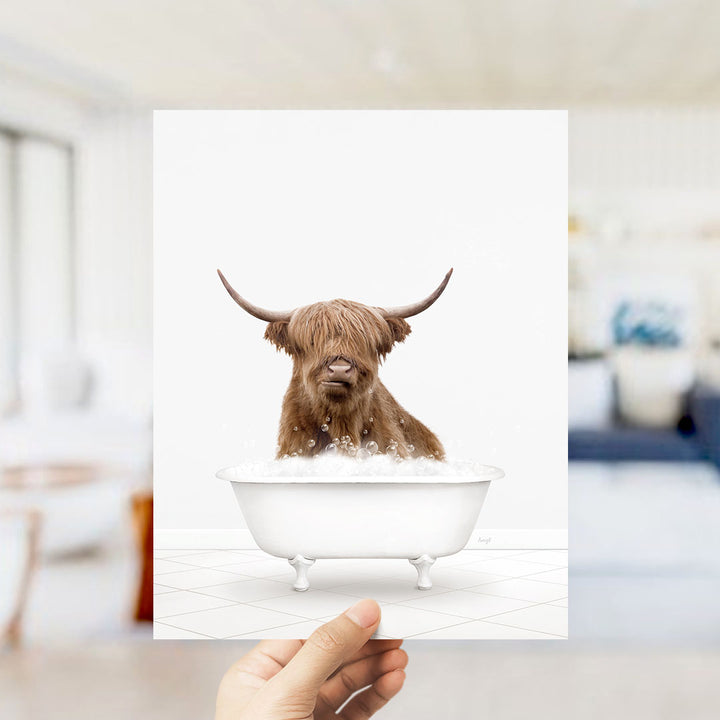 A brown cow with long horns is sitting in a white bathtub filled with water, appearing to enjoy a relaxing bath.