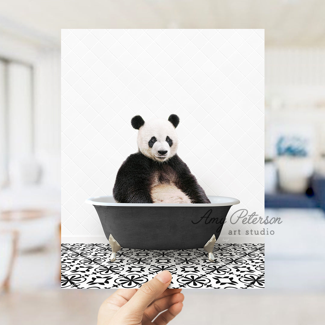 a panda bear sitting in a black and white bath tub