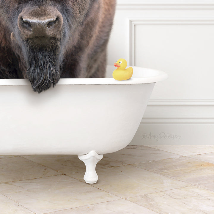 A large brown buffalo with a long beard is standing in a white bathtub, with a yellow rubber duck sitting on the edge of the tub.