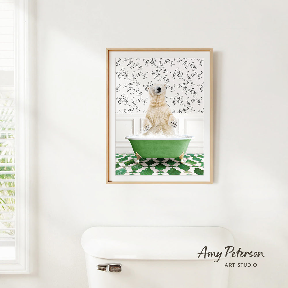 A framed image of a polar bear sitting in a green bathtub, surrounded by a patterned wall and a white toilet in a bathroom setting.