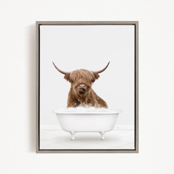 A brown cow with long horns is sitting in a white bathtub filled with water, creating a whimsical and playful scene.