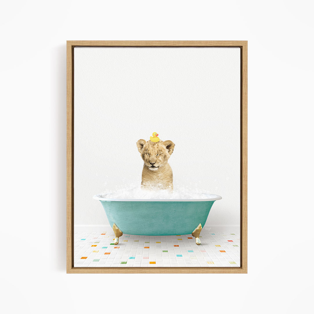 A young lion cub is sitting in a blue bathtub filled with water, with a yellow rubber duck perched on its head.