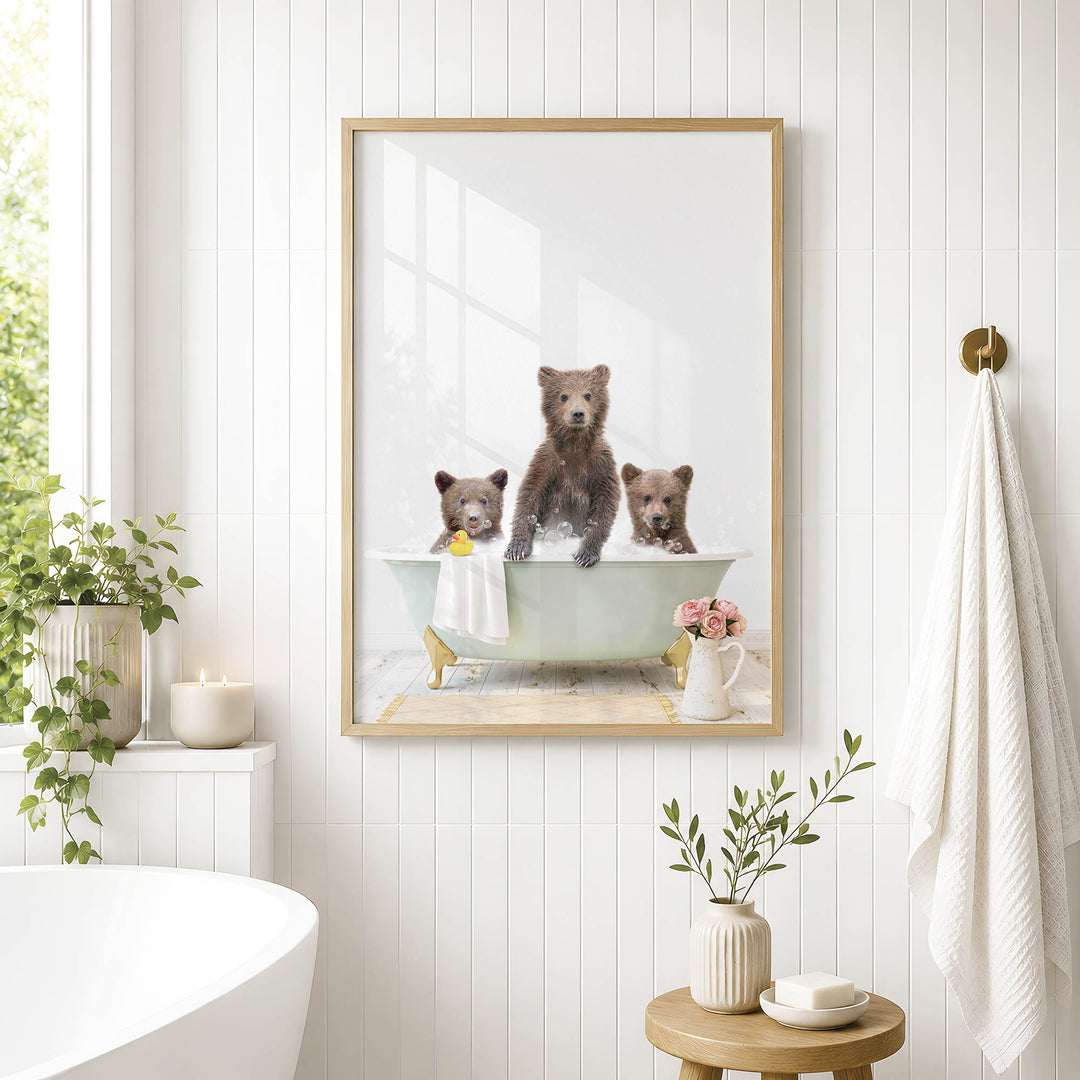 A framed image of three bears sitting in a bathtub, with one bear sitting on the edge of the tub and the other two bears sitting inside the tub.