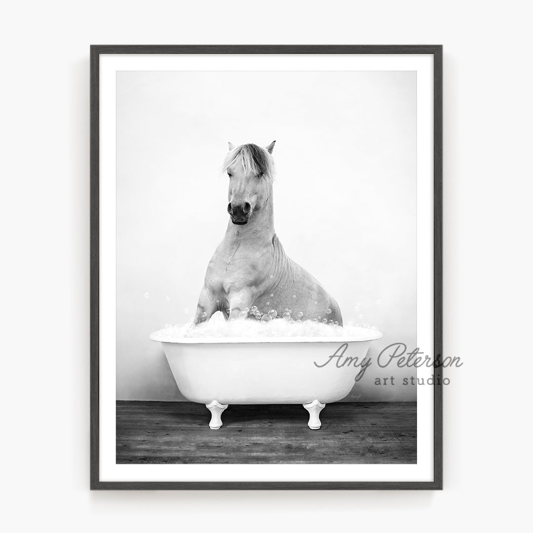 a black and white photo of a horse in a bathtub