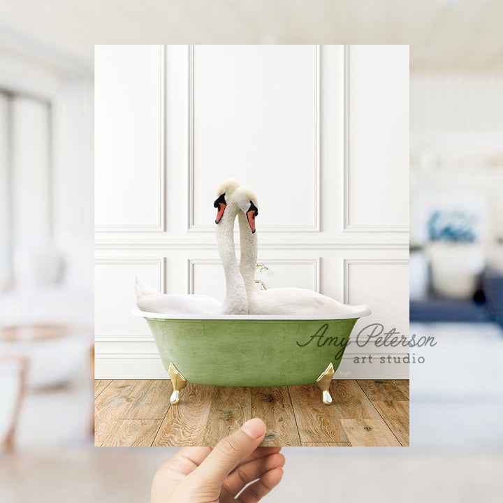 a person holding up a picture of a swan in a bathtub