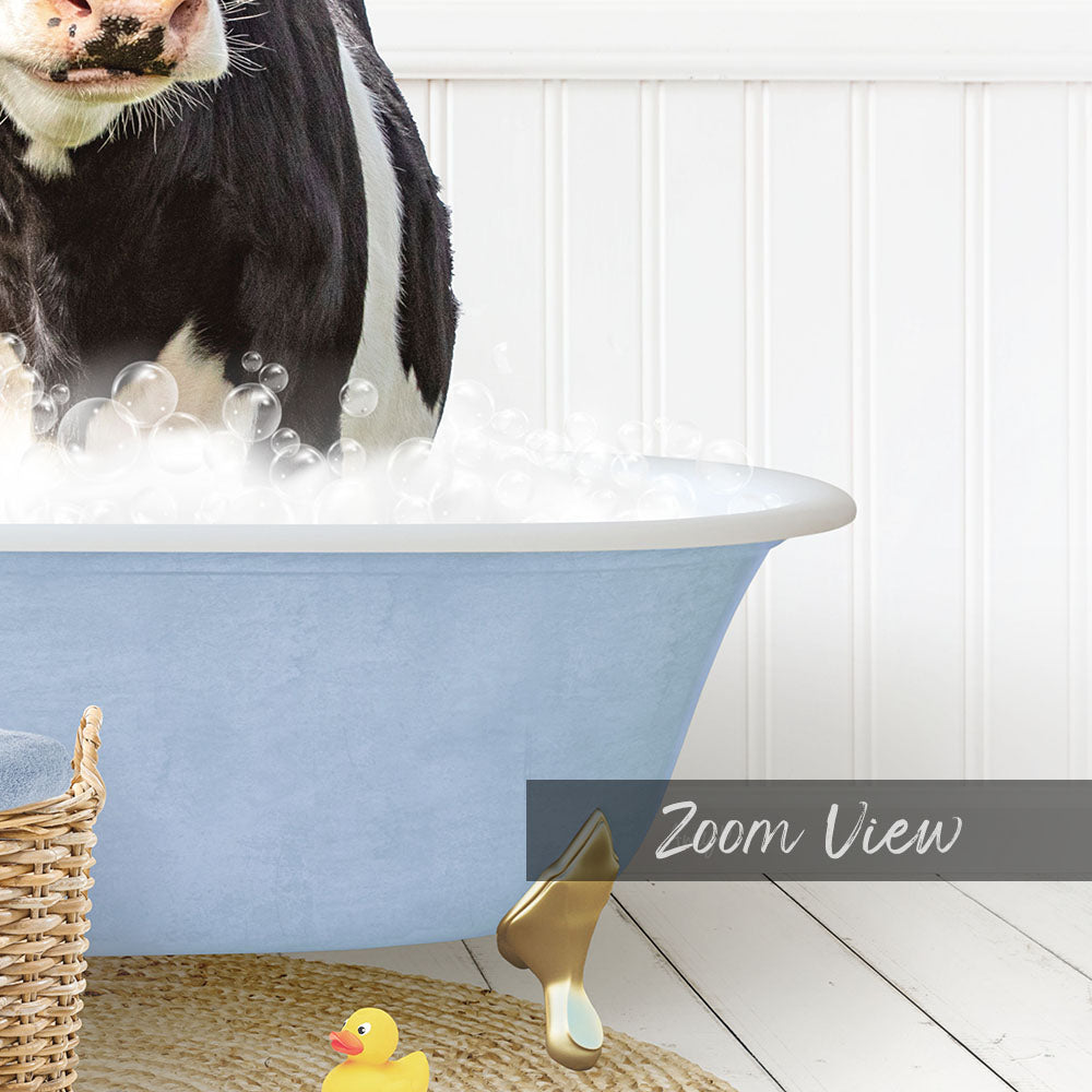 A black and white cow is standing in a blue bathtub filled with bubbles, with a yellow rubber duck nearby.
