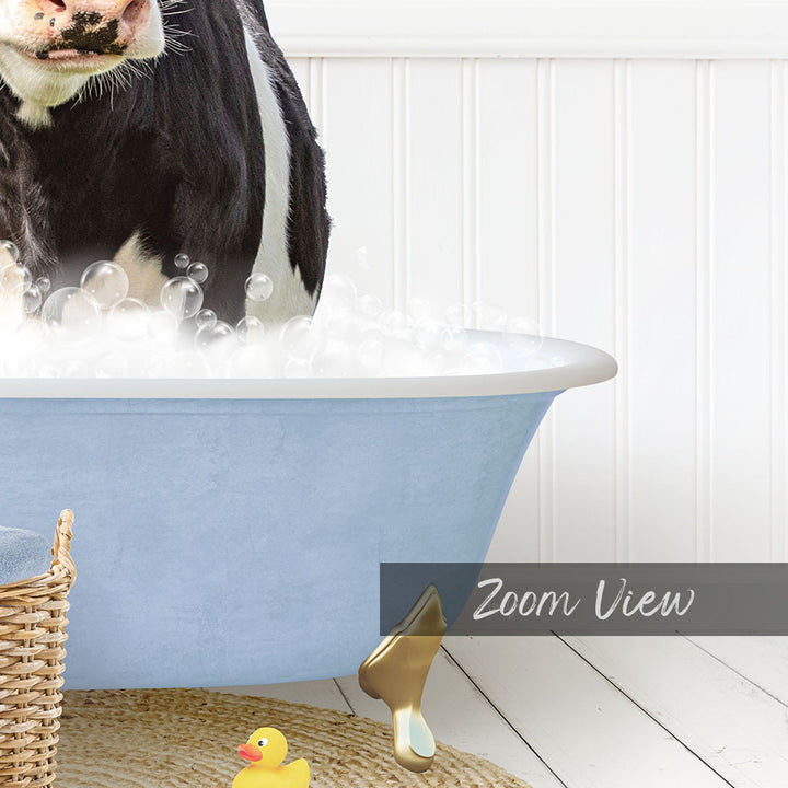 A black and white cow is standing in a blue bathtub filled with bubbles, with a yellow rubber duck nearby.