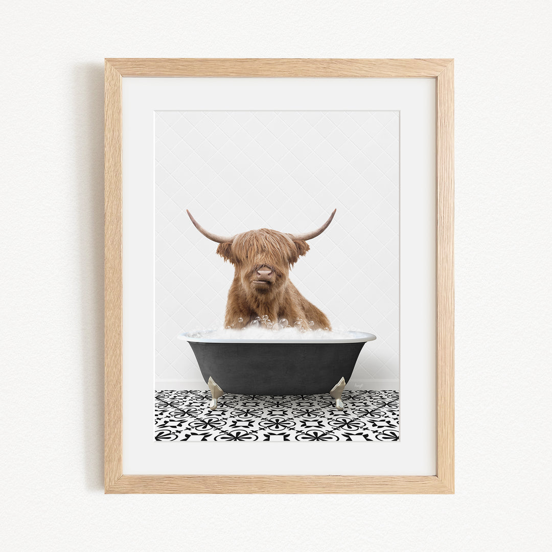 A Highland cow with long horns is sitting in a bathtub filled with water, creating a whimsical and playful scene.