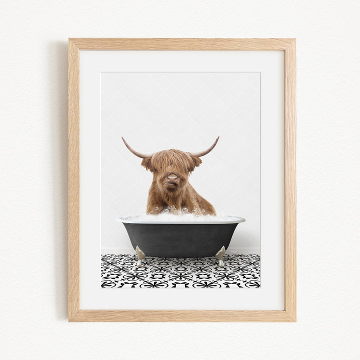 A Highland cow with long horns is sitting in a bathtub filled with water, creating a whimsical and playful scene.
