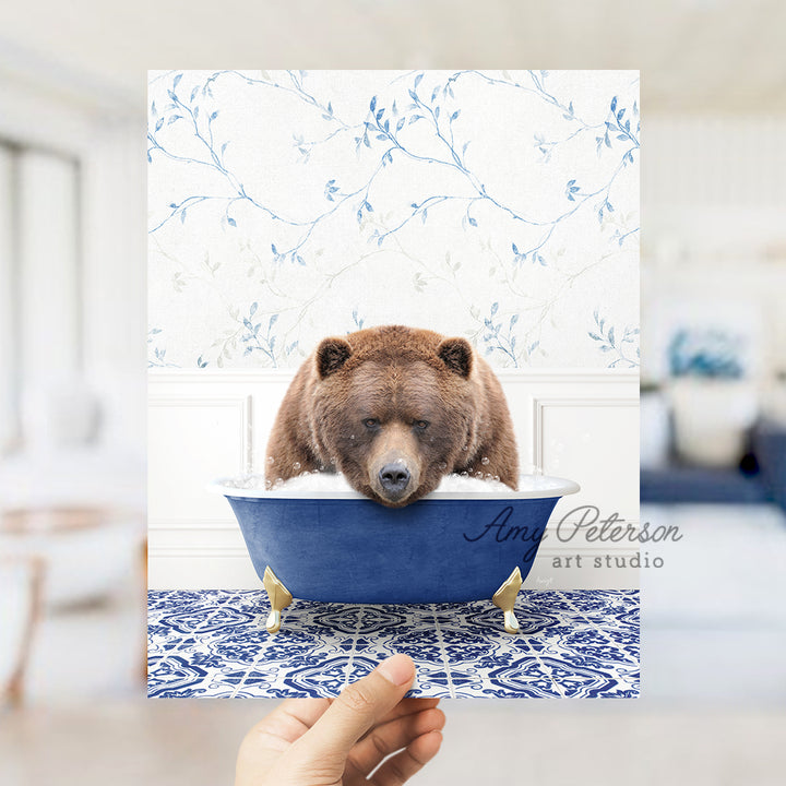 a hand holding a card with a bear in a bathtub