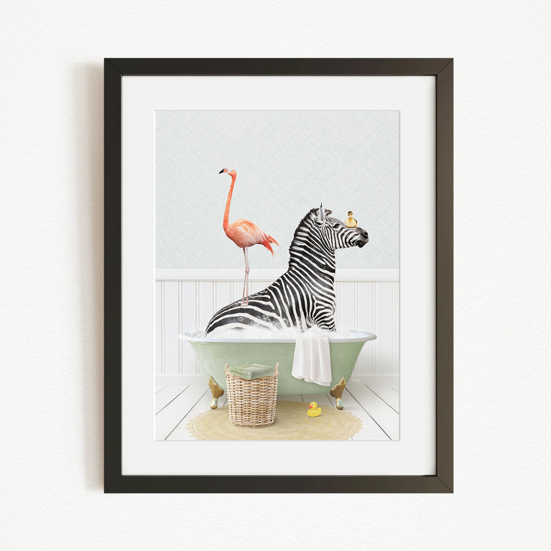 A framed image depicting a zebra sitting in a bathtub, with a flamingo standing on its back and a basket of rubber ducks nearby.