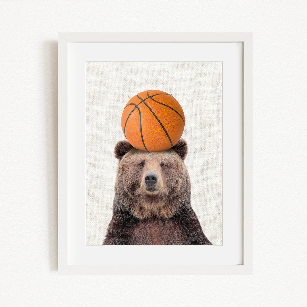 A brown bear balancing a basketball on its head.