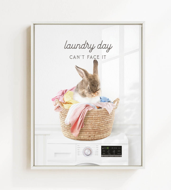 A cute rabbit sitting in a woven laundry basket filled with clothes, with the text "laundry day can't face it" above the image.