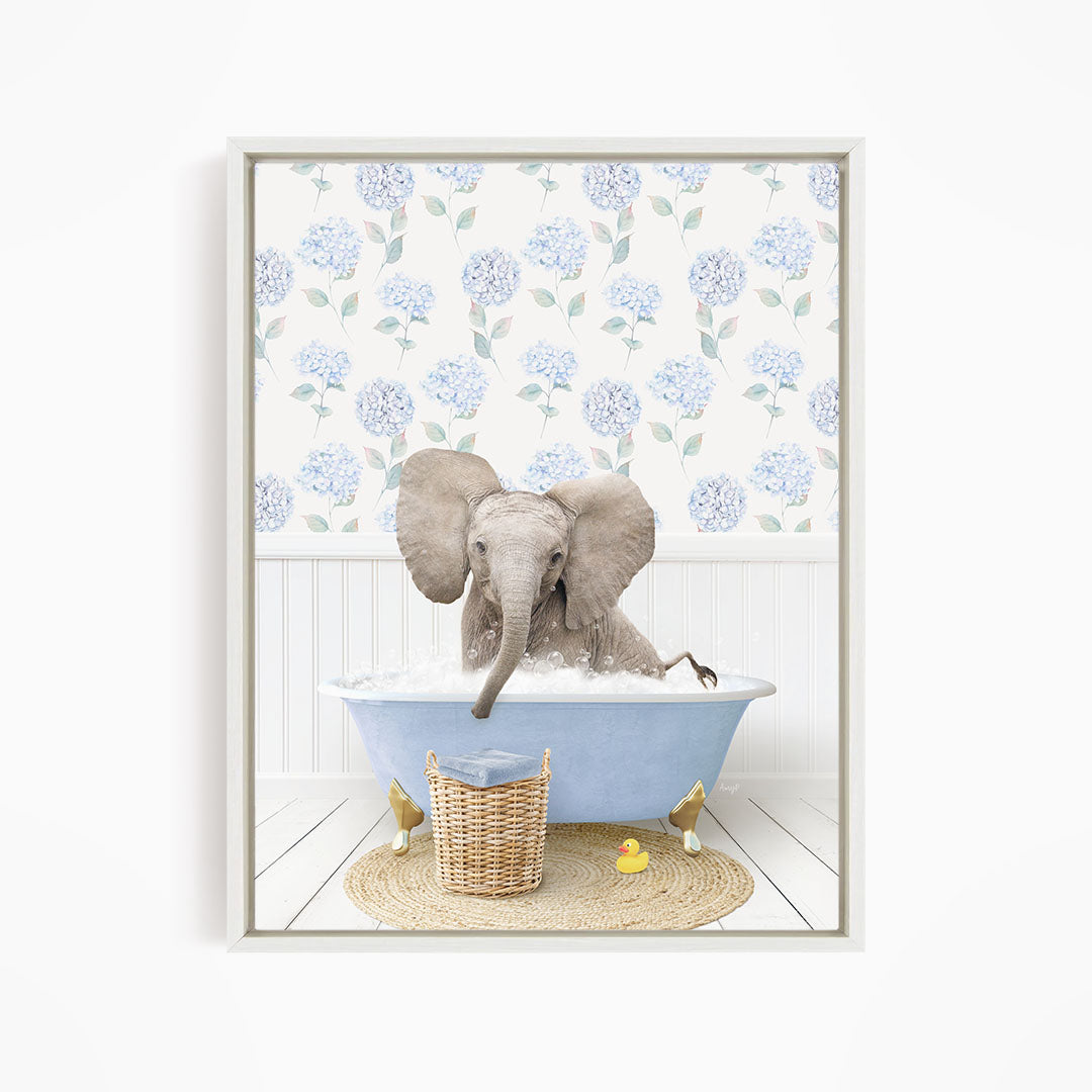 A gray elephant is sitting in a blue bathtub filled with water, surrounded by a wicker basket and yellow rubber ducks.